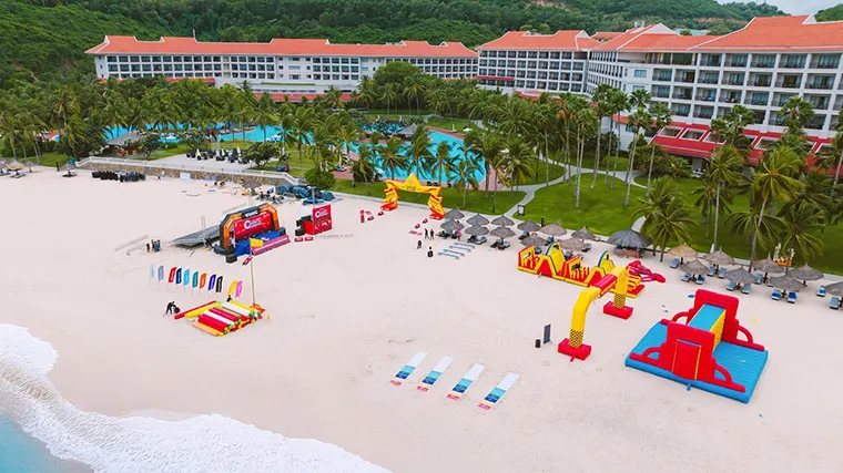 Red-roofed buildings stand out on the white sand beach